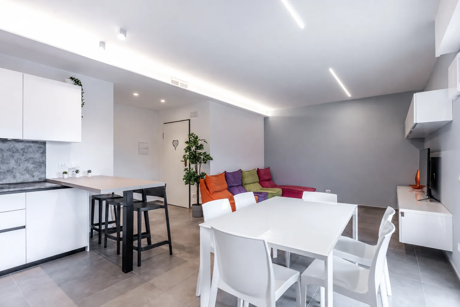 Zona pranzo e soggiorno luminoso con cucina a vista ad Albaro